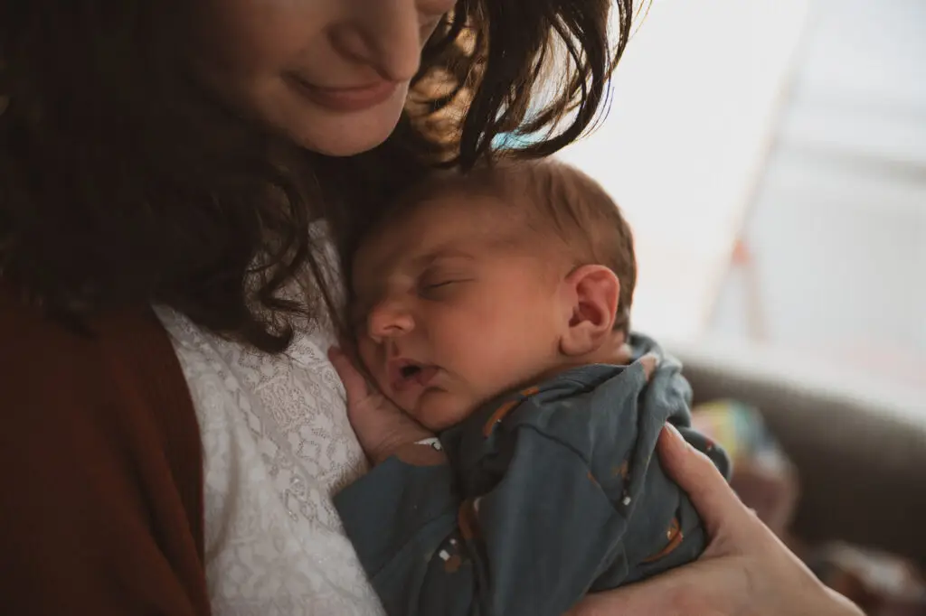 fotoshoot newborn baby bij moeder aan het slapen